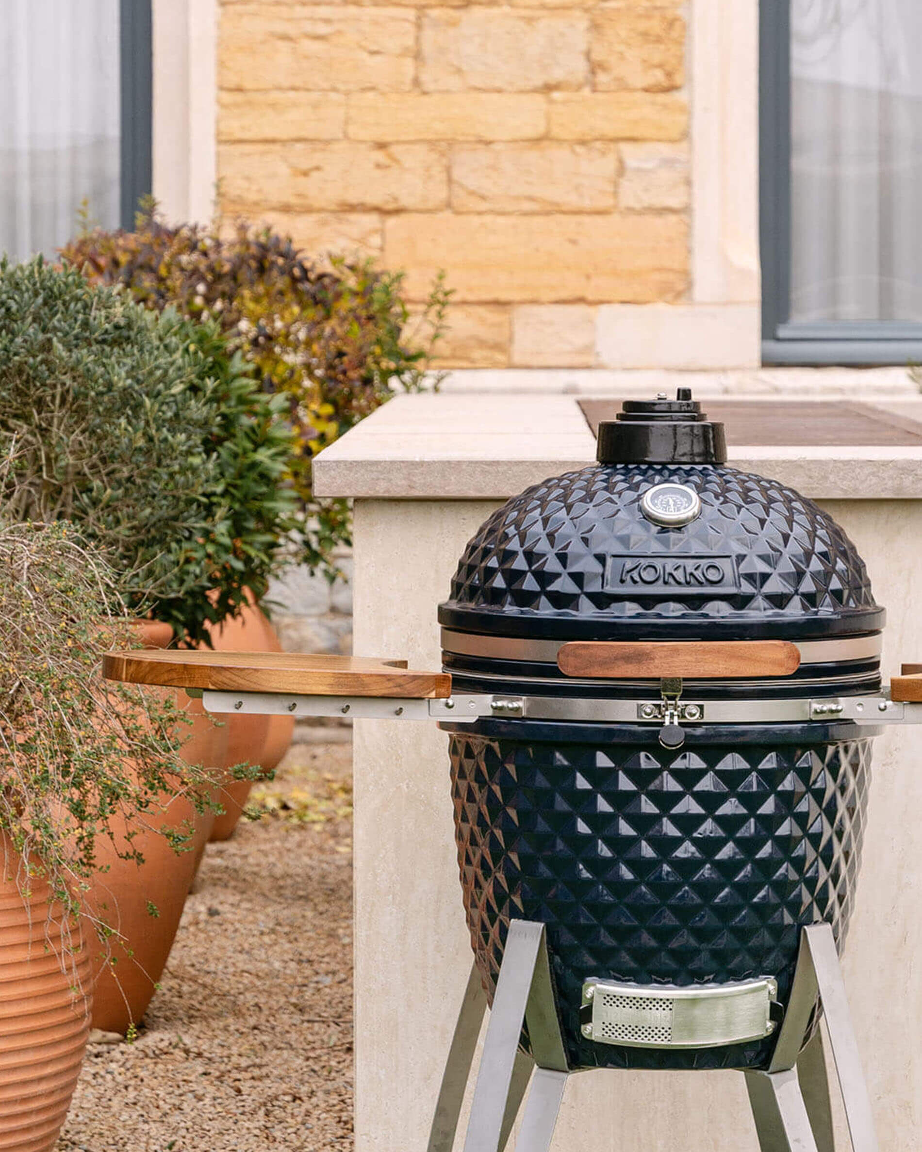 Barbecue kamado Kokko 22 pouces coloris navy, présenté seul en extérieur.