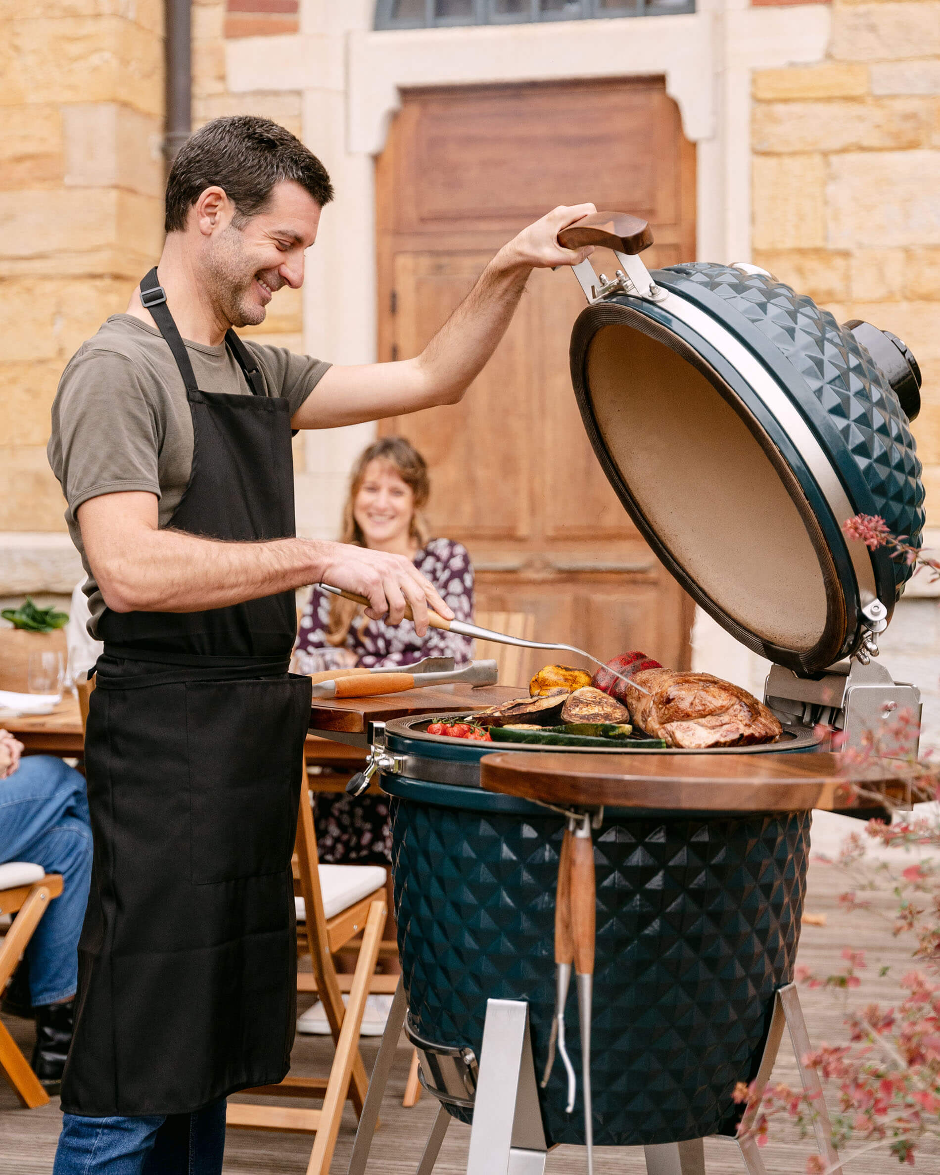 Kamado Kokko XL 22 pouces en céramique bleu océan en cours d’utilisation.