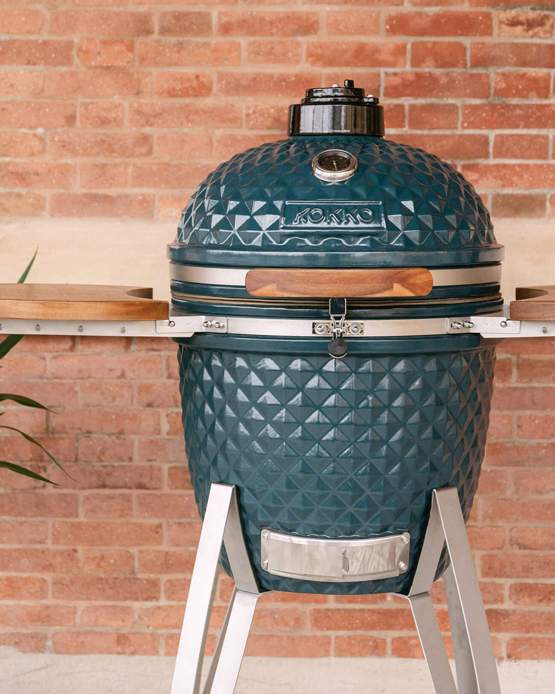 Barbecue kamado Kokko 22 pouces coloris océan, présenté seul en extérieur.