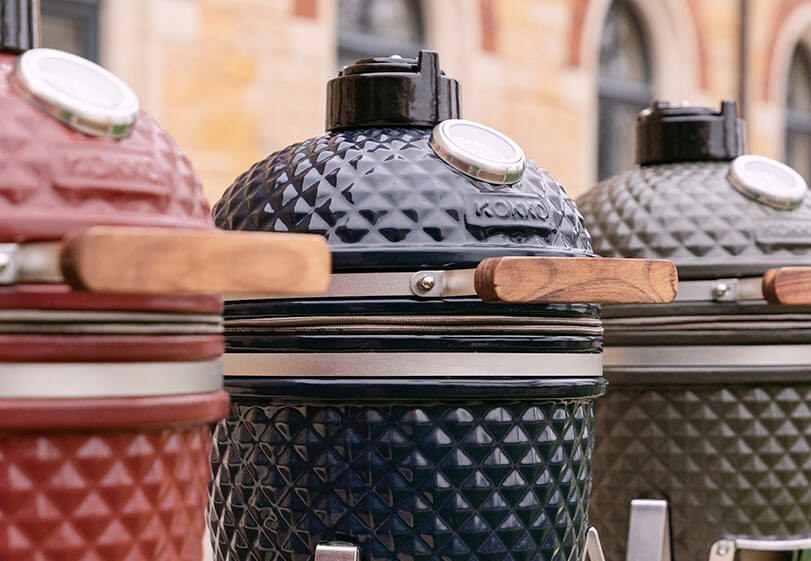 Alignement de kamados Kokko de différents modèles et couleurs, présentés côte à côte en extérieur.